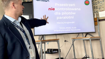 Maciej Krajewski prezentuje tytuł wykładu "Przestrzeń [nie]kontrolowana dla pilotów paralotni"